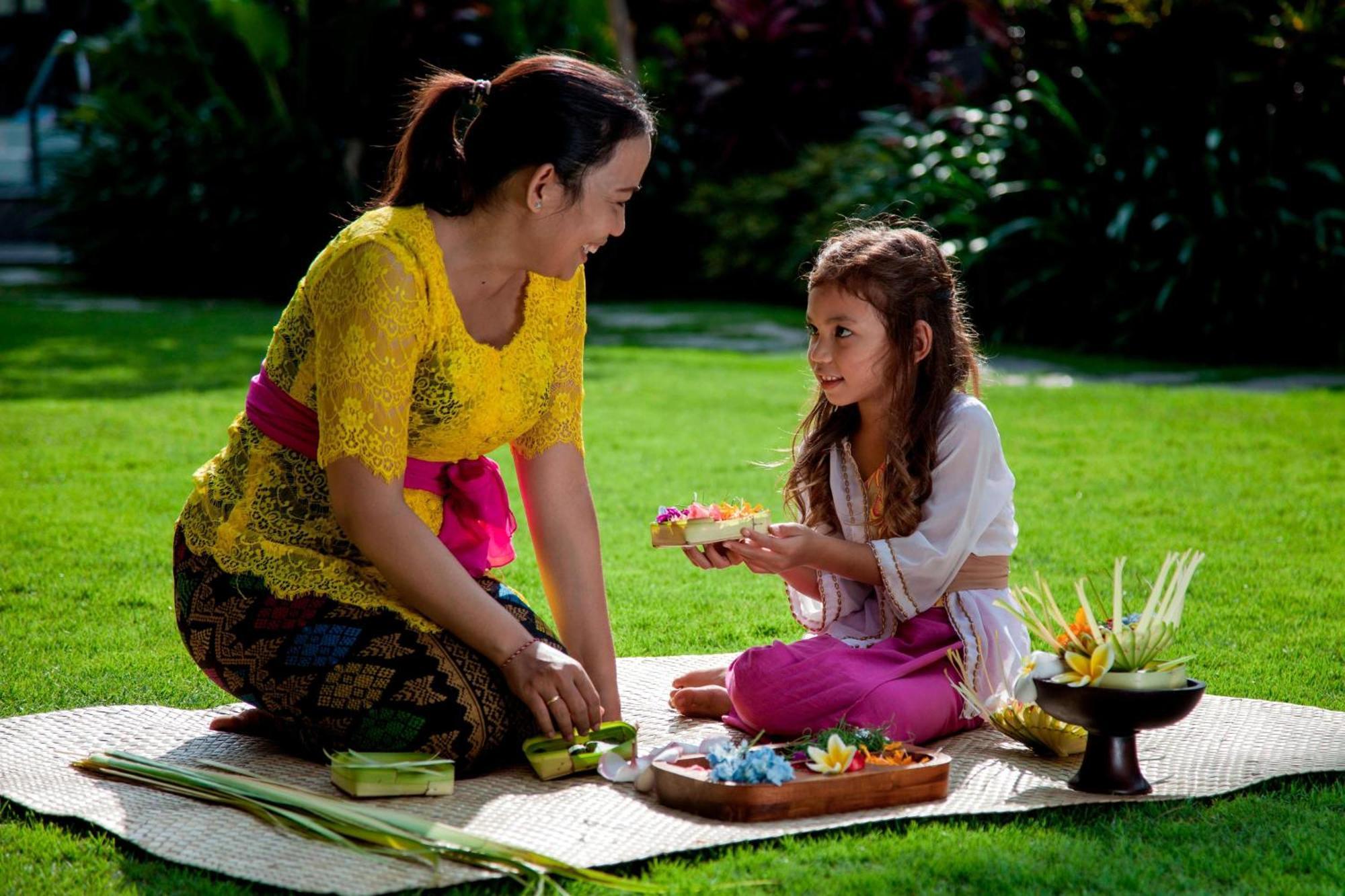 Courtyard By Marriott Bali Seminyak Resort Ngoại thất bức ảnh A Balinese Hindu woman and her daughter preparing offerings.